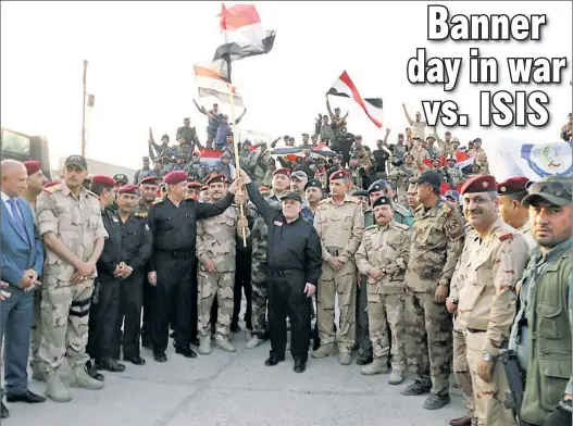  ??  ?? Prime Minister Haider al-Abadi (center) proudly raises high the Iraqi flag in Mosul on Monday after Iraqi, Kurdish and US forces combined to liberate the nation’s second-largest city from ISIS control. ISIS chief Abu Bakr al-Baghdadi had originally...