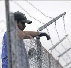  ?? ERIC GAY/AP ?? A worker installs barbed-wire on top of a fence at a U.S. Customs and Border Protection temporary holding facility near the Donna-Rio Bravo Internatio­nal Bridge on Wednesday in Donna, Texas.