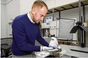  ?? ?? Ross Hoffman, CEO of Collectors Vault, shows a shoe worn and signed by NBA legend Kobe Bryant on Oct. 21, in Delaware. The footwear is among hundreds of items stored at Collectors Vault.