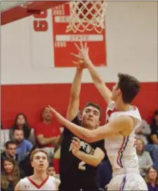  ?? KYLE FRANKO — TRENTONIAN PHOTO ?? Hopewell Valley’s Kevin O’Reilly, center, scores a basket over Ocean Twp.’s Jack Miller, left, and Corey Miller, right, during the Molinelli Classic final at Lawrence High on Friday night.