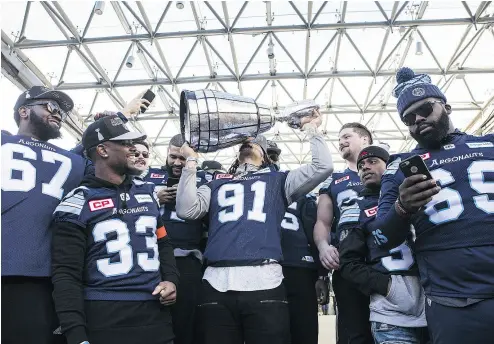  ?? THE CANADIAN PRESS / CHRIS YOUNG ?? Toronto Argonauts defensive tackle Alan-Michael Cash kisses the Grey Cup during a rally on Tuesday in Toronto’s Nathan Phillips Square. The Argonauts were celebratin­g Sunday’s 27-24 Grey Cup win over the Calgary Stampeders.