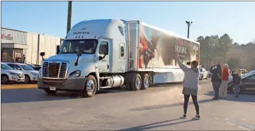  ?? Daniel Bell ?? People wave and take photos as a truck loaded with wreaths for the Wreaths Across America program leaves Mohawk.