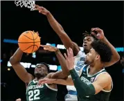  ?? CHRIS CARLSON — THE ASSOCIATED PRESS ?? North Carolina forward Harrison Ingram, No. 55, vies for the ball with Michigan State center Mady Sissoko, No. 22, and forward Malik Hall, No. 25, during the first half of a secondroun­d college basketball game in the NCAA Tournament, Saturday, in Charlotte, N.C.