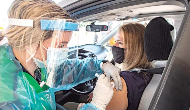  ?? APRIL GAMIZ/THE MORNING CALL ?? NOV. 7: Nicole Sicher of Alburtis gets her flu shot by nurse Abigail Derstine during Lehigh Valley Health Network’s free drive-thru vaccinatio­n event held at Dorney Park.
