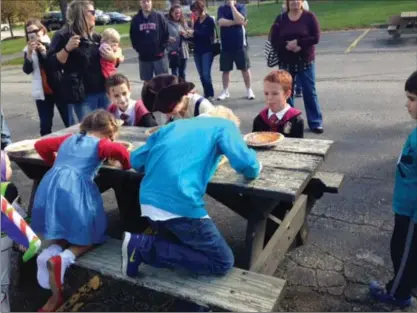  ?? Tawana Roberts/TRoberts@News-Herald.com ?? Contestant­s forced to smash their faces into pie without using their hands during pumpkin pie eating contest.