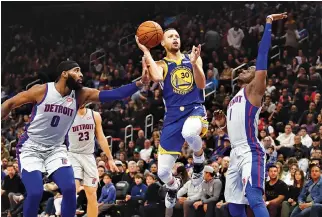  ?? RAJ MEHTA-USA TODAY SPORTS ?? GOLDEN STATE WARRIORS guard Stephen Curry (30) shoots against Detroit Pistons center Andre Drummond (0) and guard Reggie Jackson (1) during the fourth quarter at Little Caesars Arena.