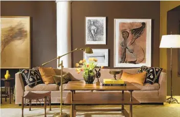  ?? GROSS & DALEY GLENN GISSLER VIA AP ?? Designer Glenn Gissler painted this New York loft in Benjamin Moore’s Van Buren Brown, with columns and ceilings in crisp Decorator’s White. A long tuxedo-style sofa in milk chocolaty velvet anchors the space.