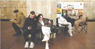  ?? (Thomas Peter/Reuters) ?? PEOPLE TAKE shelter in a metro station during a Russian missile strike on Kyiv yesterday.