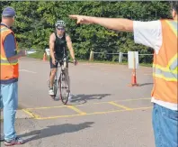  ?? ERIC MCCARTHY/JOURNAL PIONEER ?? Cory Birch is directed towards the transition area as he finishes the bike leg of the sprint triathlon. The event starts with a 750-meter swim, then a 20-km bike race and finishes with a five –km run. Birch finished second overall.