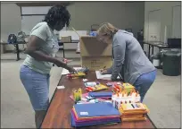  ??  ?? Rhonda Carter, left, and Michelle Graf, both United Way volunteers, sort through donations at the Day of Caring school supply drive.