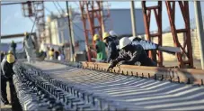  ??  ?? Workers fix steel rail track sections to concrete sleepers. The Free Trade Area will yield major economic benefits for the continent, says the writer.