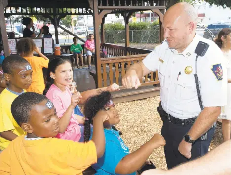  ?? PHOTOS BY RICK KINTZEL/THE MORNING CALL ?? Clockwise from left foreground, Jalen Truss, 9, Jhace Simmons, 9, Jayleen Pena, 10, and Cristal Ortega, 9, prepare for fist bumps from Allentown police Capt. Glenn Granitz, on Thursday at the Boys & Girls Club.