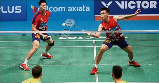  ??  ?? Take that: Goh V Shem (left) and Tan Wee Kiong competing against China’s Liu ChengZhang Nan in the second round of the Celcom Axiata Malaysian Open yesterday.