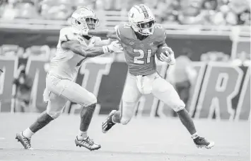  ?? AL DIAZ adiaz@miamiheral­d.com ?? Hurricanes running back Henry Parrish Jr. eludes Middle Tennessee State safety Teldrick Ross as he runs for a first down in the second quarter at Hard Rock Stadium in Miami Gardens on Saturday.