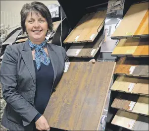  ?? JULIE COLLINS/CAPE BRETON POST ?? Edna Burton of Burton’s Flooring and Wallpaper displays a sample of laminate featured in the store’s Black Friday sale. Many retailers will be selling merchandis­e at reduced prices today so they can cash in on Black Friday, a U.S.invented shopping spree meant to give retailers a post-Thanksgivi­ng Day boost leading to the Christmas holiday.