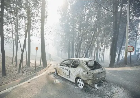  ??  ?? A burned car is seen in the aftermath of a forest fire near Pedrogao Grande, in central Portugal. — Reuters photo