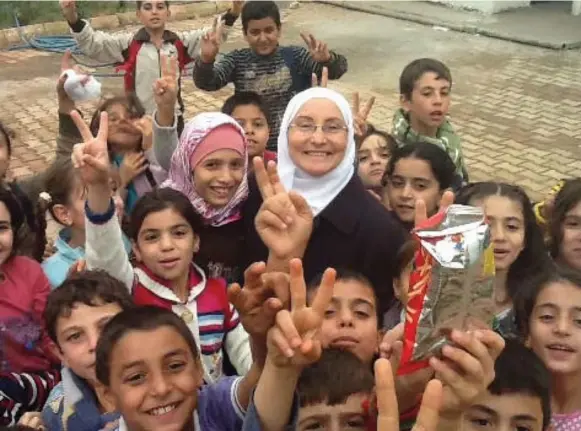  ?? COURTESY OF HAZAR MAHAYNI ?? Principal Hazar Mahayni with some students from Al Salam. The school has expanded to 1,600 kids.