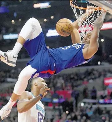  ?? Michael Owen Baker Associated Press ?? THE CLIPPERS’ C.J. Williams puts the finishing touches on a dunk after getting past Charlotte’s Dwight Howard during the second half. The Clippers have won five of their last six games.