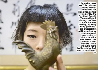  ?? AFP ?? Feng shui master Thierry Chow holds a metal rooster in her Hong Kong office yesterday. US President Donald Trump will strut through the Year of the Rooster thriving, as Hong Kong geomancers predict 2017 will be marked by arguments and aggression —...