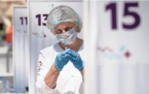  ?? ALEXANDER ZEMLIANICH­ENKO/AP ?? A medical worker prepares an injection of Russia’s Sputnik V coronaviru­s vaccine at a vaccinatio­n center in Moscow.