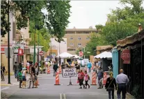  ?? LUIS SÁNCHEZ SATURNO/NEW MEXICAN FILE PHOTO ?? People walk downtown as artists set up for the Santa Fe Indian Market in 2019, the last live market before the coronaviru­s pandemic. This year’s market is likely to be the first in the event’s history with paid entry and timed admissions.