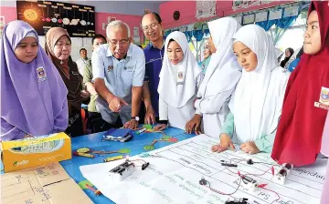  ??  ?? Mahdzir (third from left) ad Madius (fourth from left) evaluating the IBSE teaching method at SK Mengkabong.
