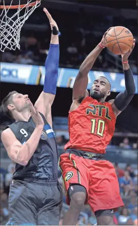  ?? Reinhold Matay / ?? Atlanta guard Tim Hardaway Jr. (10) goes for the layup as Orlando center Nikola Vucevic defends during Saturday’s game.