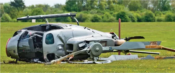  ??  ?? Aftermath: The badly damaged helicopter lies on its side with its rotors broken and windows smashed after the crash at an airfield