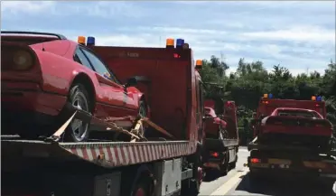  ?? FOTO: SØIK ?? Her får politiet kørt de tre røde Ferrarier væk til en hemmelig adresse. Bilerne var uden nummerplad­er og har en værdi på cirka to millioner kr.