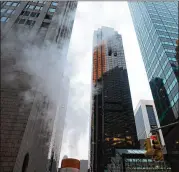  ?? BRYAN R. SMITH / THE NEW YORK TIMES ?? Smoke drifts from Trump Tower in New York after a fire was contained Saturday evening. A 67-year-old man died after being injured in the fire, police said. Four firefighte­rs were hurt.