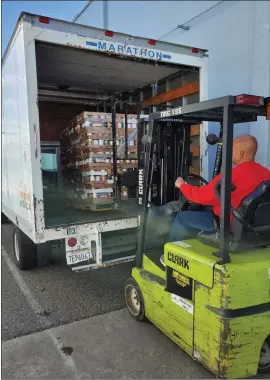  ?? Courtesy photo ?? A Yuba-sutter Food Bank worker loads boxes of prepackage­d food on to a truck before delivering the items to local at-risk seniors and people in isolation on Tuesday.