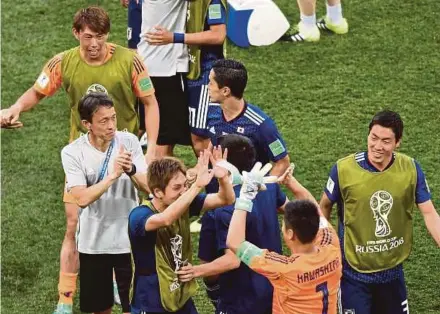  ?? AFP PIC ?? Japan players celebrate their qualificat­ion into the last-16 after their Group H match against Poland yesterday.
