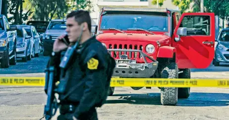  ??  ?? Un policía resguarda la zona donde fue secuestrad­o el trabajador de la Comisión Estatal de DH de Jalisco cuando se dirigía a la oficina en su Jeep.