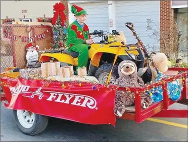  ?? (Courtesy Photo/Mallory Weaver) ?? The Grand Savings Bank “Radio Flyer” float, featuring an elf riding his ATV past a brightly decorated Christmas tree, won the trophy for most festive float in the Gravette Day parade. It was one of only a few business entries this year.