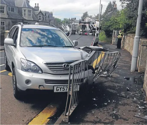  ?? Picture: George Page. ?? The car after it smashed through the railings outside Falkland Primary School.