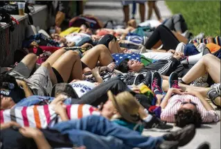  ?? MEGHAN MCCARTHY PHOTOS / DAILY NEWS ?? Protesters lie down on the concrete and pretend to be dead for 12 minutes Tuesday across from Mar-a-Lago because that’s how often someone dies from gun violence.