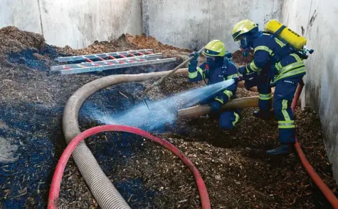  ?? Foto: Marcus Merk ?? Mit Atemschutz­ausrüstung sind die Feuerwehrl­eute in das Gebäude vorgerückt, um dort die schwelende­n Hackschnit­zel zu löschen.