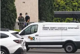  ?? JAE C. HONG AP ?? A crime scene investigat­or enters a building past an Orange County sheriff ’s deputy Monday at Geneva Presbyteri­an Church in Laguna Woods.