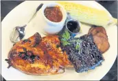  ?? STAFF FILE PHOTO ?? The Back Porch platter, a barbecue chicken, ribs and tri-tip combo, is served with two sides — here, barbecue beans and corn on the cob — at Lucille’s Smokehouse Bar-B-Que.