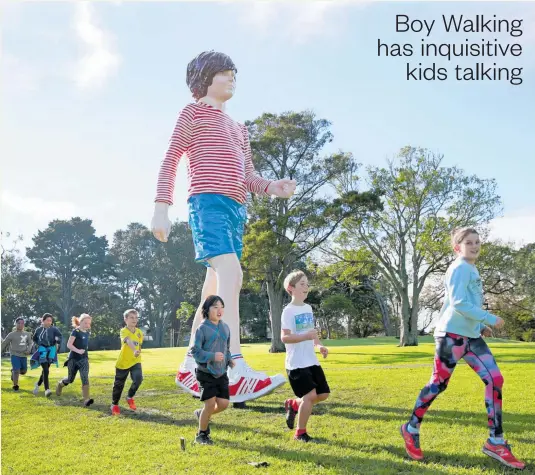  ?? Photo / Alex Burton ?? Ronnie van Hout’s sculpture, Boy Walking, has company in Potters Park, Auckland. And, no, the new arrival isn’t heading off in search of Maccas.