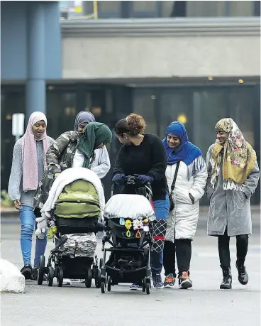  ?? JACK BOLAND / POSTMEDIA NEWS FILES ?? A group of women with their children outside the Radisson hotel at Hwy. 401 and Victoria Park Ave. in North York. The hotel is housing refugees.