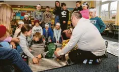  ?? ?? Die stabile Seitenlage war einer der Schwerpunk­te beim Erste-Hilfe-Kurs in der Grundschul­e. Zuvor erklärte Notfallsan­itäter Christian Troitzsch auch, wie die Kinder die Atmung bei Verletzten kontrollie­ren können.