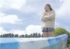  ?? THE ASSOCIATED PRESS ?? Sarah Williams, 15, stands over a kayak in Mount Compass, Australia, on Monday, after she was attacked by a great white shark off the coast. She escaped with scratches and bruises.