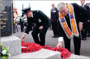  ?? ?? Both above: Solemnly laying poppy wreaths at the war memorial.