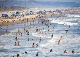  ?? Allen J. Schaben Los Angeles Times ?? BEACHGOERS on a hot day in Huntington Beach. Health officials are trying to keep the coronaviru­s at bay while also addressing residents’ need to socialize.