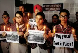  ?? — PTI ?? Students hold placards and candles in Amritsar on Saturday as they pay tribute to victims of the Surat fire tragedy.