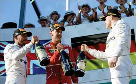  ?? FOTO: EPA/TRACEY NEARMY ?? PODIUM. Valtteri Bottas (t.v.), Lewis Hamilton (t.h.) och Sebastian Vettel firade med champagne i Melbourne.