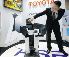  ?? SHIZUO KAMBAYASHI/THE ASSOCIATED PRESS ?? Akifumi Tamaoki, general manager of Toyota’s partner robot division, demonstrat­es HSR or Human Support Robot at the Internatio­nal Robot exhibition in Tokyo.