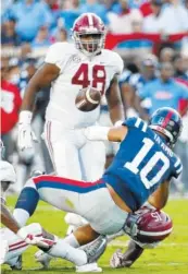  ?? AP PHOTO/ROGELIO V. SOLIS ?? Ole Miss quarterbac­k Jordan Ta’amu fumbles after getting hit by Alabama’s Xavier McKinney during Saturday’s game in Oxford, Miss. Alabama won 62-7.