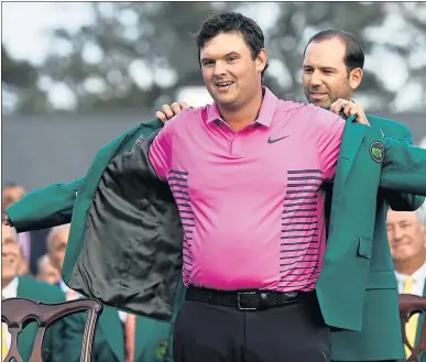  ?? DAVID J. PHILLIPS — THE ASSOCIATED PRESS ?? Sergio Garcia helps Patrick Reed with his green jacket after he won the Masters title Sunday by one shot over Rickie Fowler.